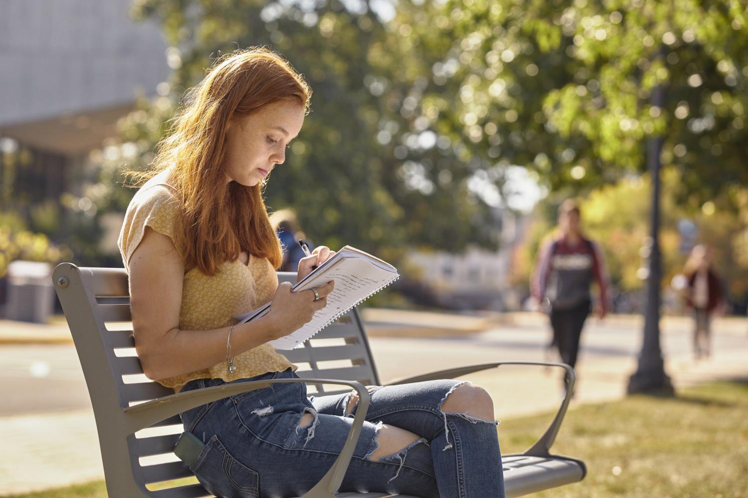 一位<a href='http://xd.4dian8.com/'>全球十大赌钱排行app</a>学院的学生在校园里的长椅上读书.